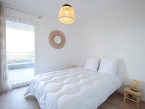 Un dormitorio blanco con una gran cama blanca y una ventana en Appartement Évian-les-Bains, 3 pièces, 4 personnes - FR-1-498-103 en Évian-les-Bains