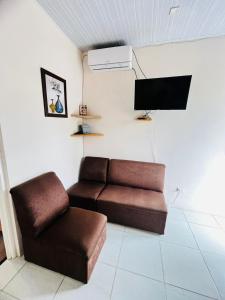 een woonkamer met een bank en een flatscreen-tv bij Melody's Modern Apartment #2 in Puerto Limón