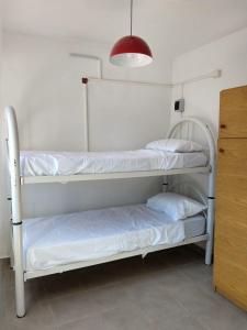 two white bunk beds in a room with a lamp at Monoambiente en Terraza in Mendoza