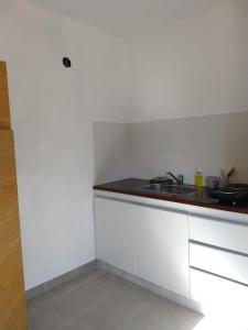 a white kitchen with a sink and a counter at Monoambiente en Terraza in Mendoza