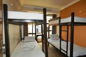 a room with three bunk beds with white sheets at Paradise Guest House in Kathmandu