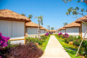 a row of houses with flowers and a pathway at K-Town Resort Phan Thiet in Phan Thiet