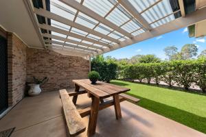 una mesa de picnic y un banco en un patio en Potters Apartments, en Cessnock