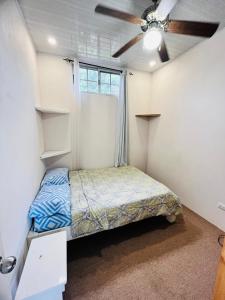 een slaapkamer met een bed en een plafondventilator bij Melody's Modern Apartment #2 in Puerto Limón