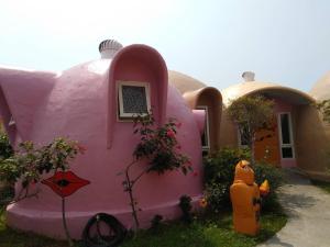 a pink house with a fire hydrant in front of it at Kenting Ha-Bi Star Fort in Hengchun South Gate