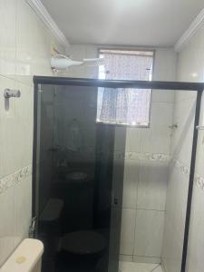 a bathroom with a shower with a toilet and a window at Apart Hotel big john 101 Vista para rua in Divinópolis