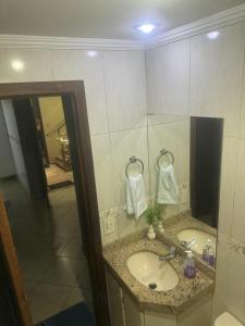 a bathroom with a sink and a mirror at Apart Hotel big john 101 Vista para rua in Divinópolis