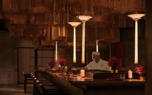 a chef standing behind a bar in a restaurant at Gran Meliá Nha Trang in Nha Trang