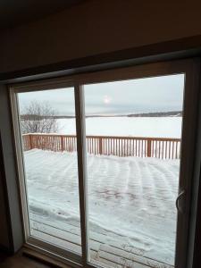 a window with a view of a snow covered yard at Top floor lakefront condo with Mountain Views! in Wasilla