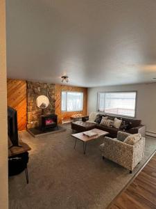 a living room with a couch and a fireplace at Top floor lakefront condo with Mountain Views! in Wasilla