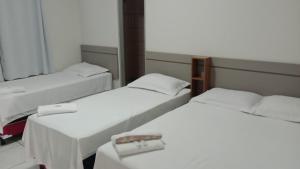un gruppo di 3 posti letto in una camera di Hotel Califórnia a Barreiras