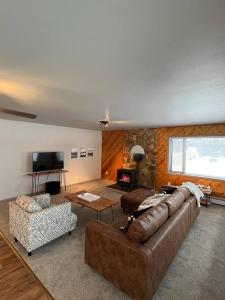 a living room with a large couch and a television at Top floor lakefront condo with Mountain Views! in Wasilla