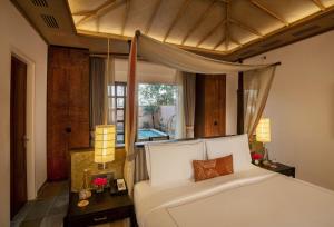 瑟瓦伊馬托布爾的住宿－Taj Sawai,Ranthambore，卧室配有白色的床和窗户。