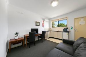 uma sala de estar com um sofá e uma mesa em Potters Apartments em Cessnock