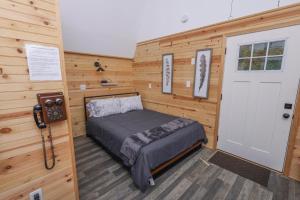 a bedroom with a bed in a room with wooden walls at Peaceful Barn Getaway Fire Pit & Daybed FREE PK in Atlanta