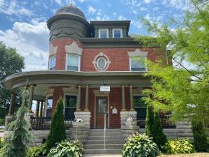 a red brick house with a round turret at The Victorian Guesthouse in Delphos