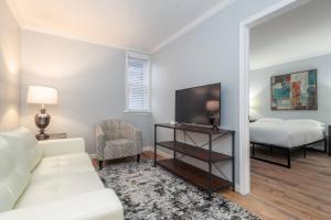 a living room with a white couch and a tv at 2 MTM Fully Furnished Rental in Old Town 2f&2r in Chicago