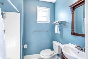 een blauwe badkamer met een toilet en een wastafel bij St Louis Townhome Perfect for Groups in Tower Grove
