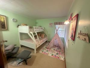 um quarto para crianças com um beliche e uma cadeira em Lucky house em Auckland