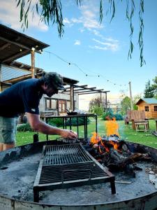 un homme debout au-dessus d'un grill avec un feu dans l'établissement Finca La Valletana, à Vista Flores