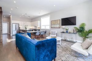 a living room with a blue couch and a kitchen at 2 Newly Built Luxury Condos with Private Roofdeck in Chicago