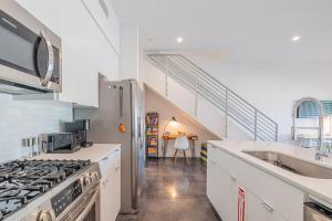 a kitchen with a stove top oven next to a staircase at Zanjero by AvantStay Mins from Downtown Palm Springs Private Terrace Shared Pool in Palm Springs