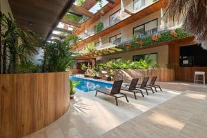 トゥルムにあるSerenity in the Sky - Studio with Rooftop and Plunge poolのプール、椅子、植物のある建物