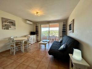 ein Wohnzimmer mit Sofa und Tisch in der Unterkunft Les Issambres : Appt 2 pièces, piscine, clim, pour 4 pers. - FR-1-226-540 in La Garonnette-Plage