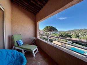 Zimmer mit einem grünen Stuhl und einem großen Fenster in der Unterkunft Les Issambres : Appt 2 pièces, piscine, clim, pour 4 pers. - FR-1-226-540 in La Garonnette-Plage