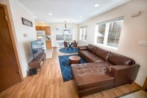a living room with a brown leather couch at Tucked Away Off Brady - 4 Beds in Milwaukee