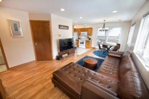 a living room with a brown leather couch at Tucked Away Off Brady - 4 Beds in Milwaukee