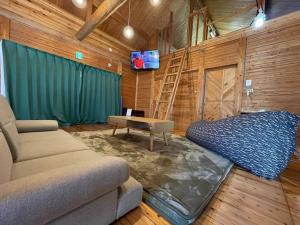 a living room with a couch and a bed at Wood retreatみやざき in Miyazaki