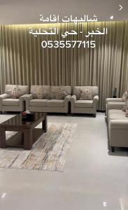 a living room with couches and a coffee table at شاليهات اقامة in Al Khobar