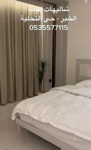 a bedroom with a white bed and a window at شاليهات اقامة in Al Khobar