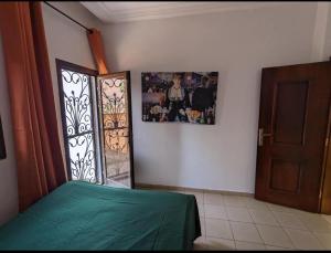 um quarto com uma cama verde e uma fotografia na parede em THE GOLF RESIDENCES YAOUNDE em Iaundé