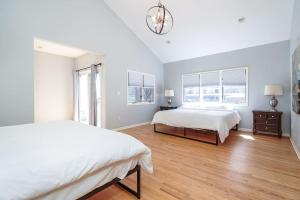 Habitación blanca con 2 camas y ventana grande. en Eclectic Stylish and Cozy Milwaukee Home en Milwaukee