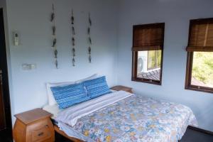 a bedroom with a bed and a blue wall at Villa Penyon in Nusa Lembongan