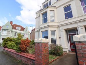 a white house with a brick wall at Mariners Lee in Llandudno