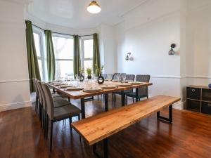 Un comedor con mesa y sillas de madera. en Mariners Lee, en Llandudno