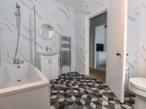 a white bathroom with a sink and a toilet at Mariners Lee in Llandudno