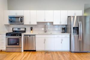 una cocina con electrodomésticos de acero inoxidable y armarios blancos en Central Chicago Suite2 Access to Patio en Chicago