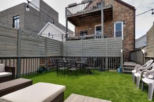 eine Terrasse mit Stühlen, einem Zaun und Gras in der Unterkunft Central Chicago Suite2 Access to Patio in Chicago