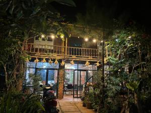 a house with a balcony and plants at night at Lily's Stone Garden bungalow in Buôn Bu Djri