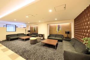 東京にあるリッチモンドホテル東京水道橋のソファとテーブル付きの広いリビングルーム