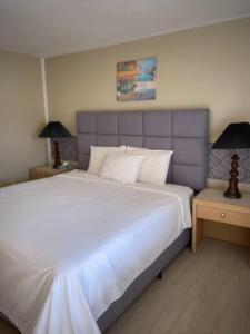 una camera da letto con un grande letto bianco con due lampade di Slumber Lodge a Hope