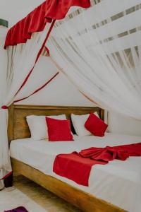 Schlafzimmer mit einem Bett mit roten und weißen Kissen in der Unterkunft Lihini Villa ii in Matara