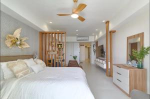 1 dormitorio con cama blanca y ventilador de techo en Juan Dolió Service Vip, en Santo Domingo