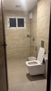 Un baño con inodoro y ventana. en Mountain Vibes Resort Wayanad, en Wayanad