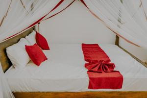 Una cama con almohadas rojas y una caja roja. en Lihini Villa ii en Matara