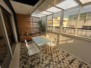 a balcony with a table and a chair on a floor at Luxueux appartement au centre de Rabat in Rabat